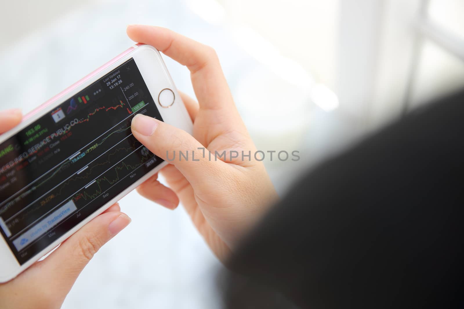 trading online on smartphone with bussiness woman hand