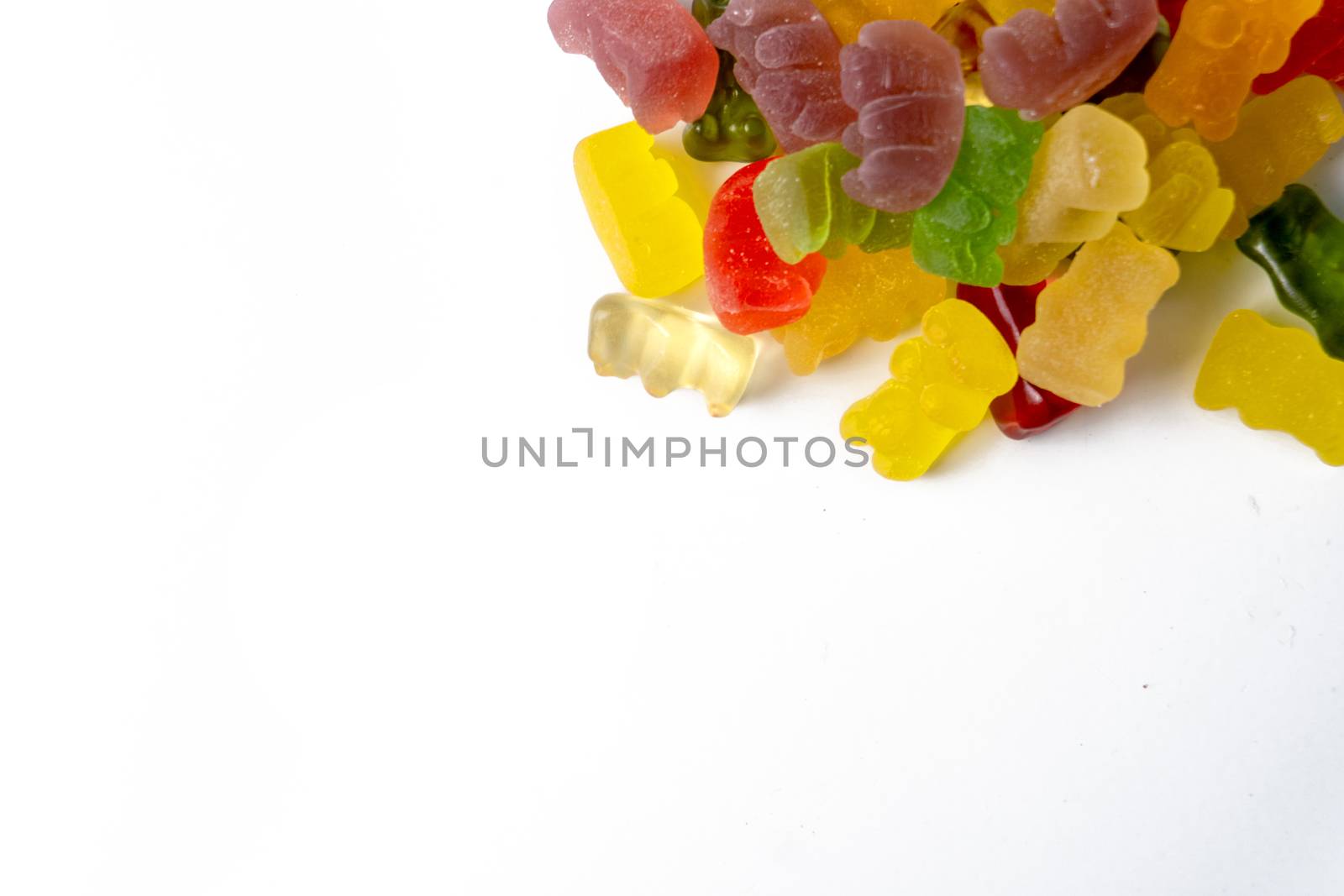 Pile of multicolored jelly bears candy on a white background.