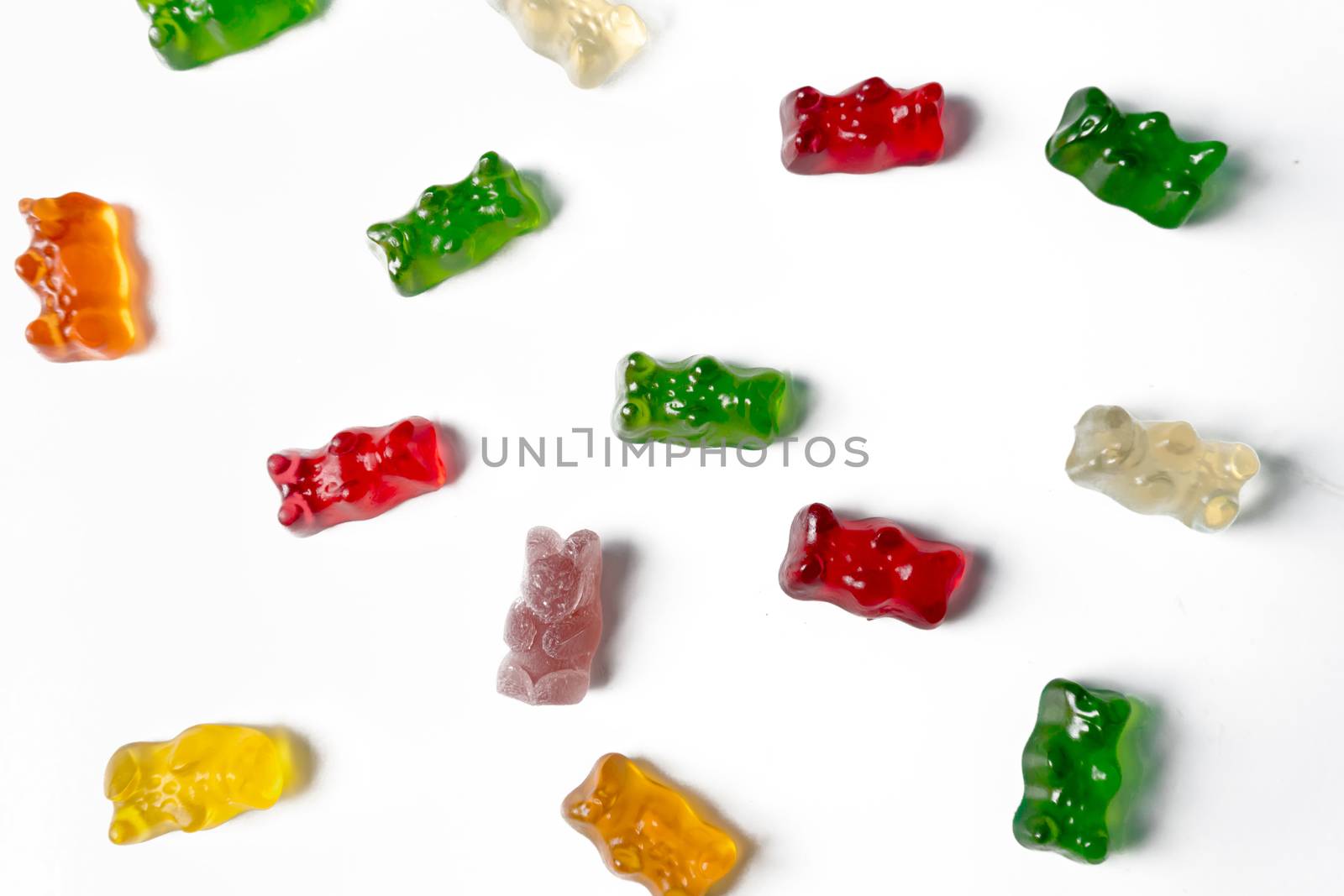 Pile of multicolored jelly bears candy on a white background.