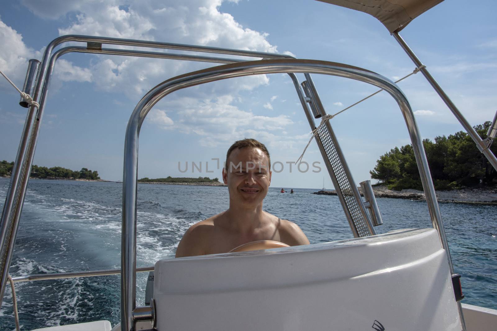 Croatia, Hvar - June 2018: Caucasian man, mid 40's drives a small boat on vacation