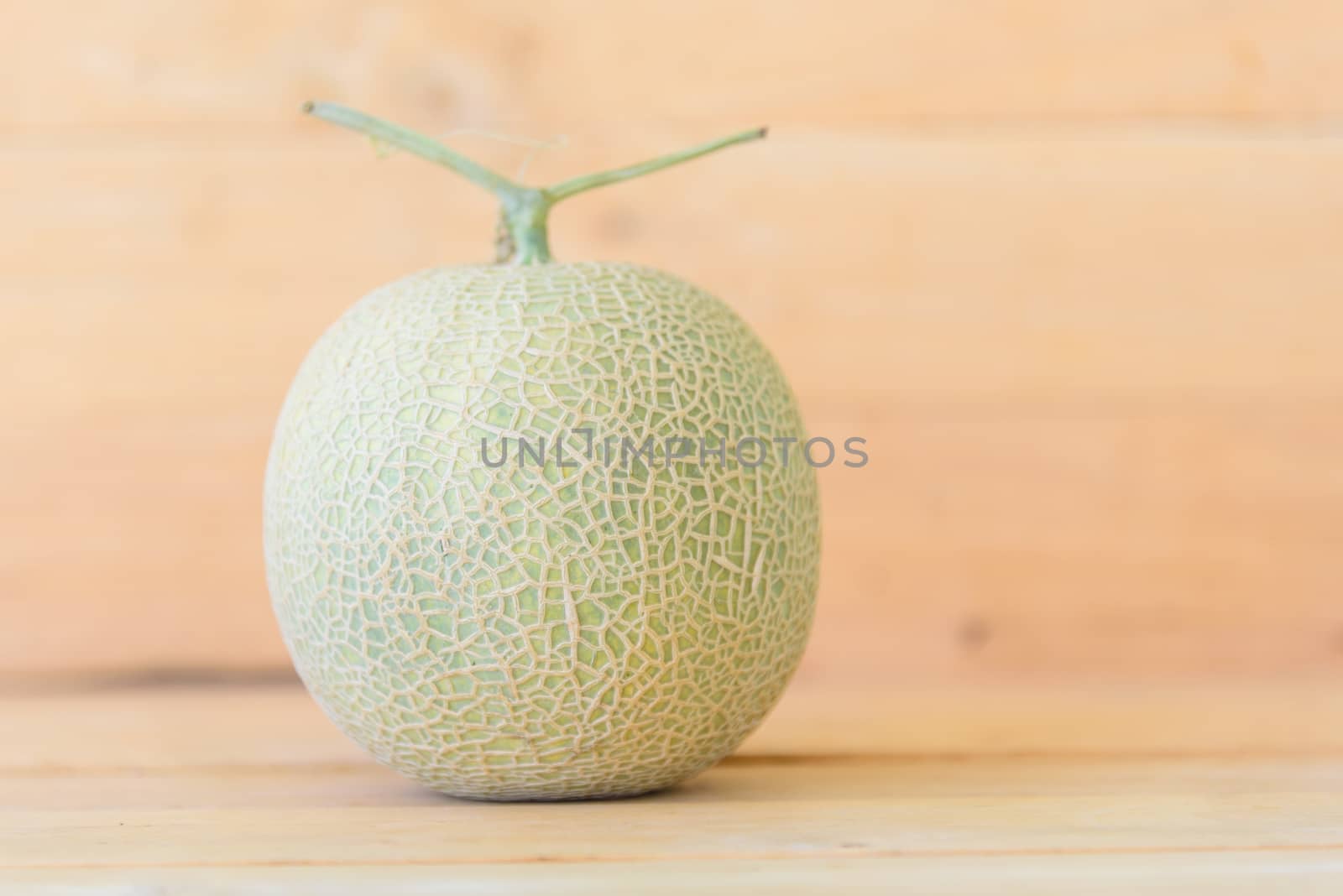 Fresh green melon on wood plate