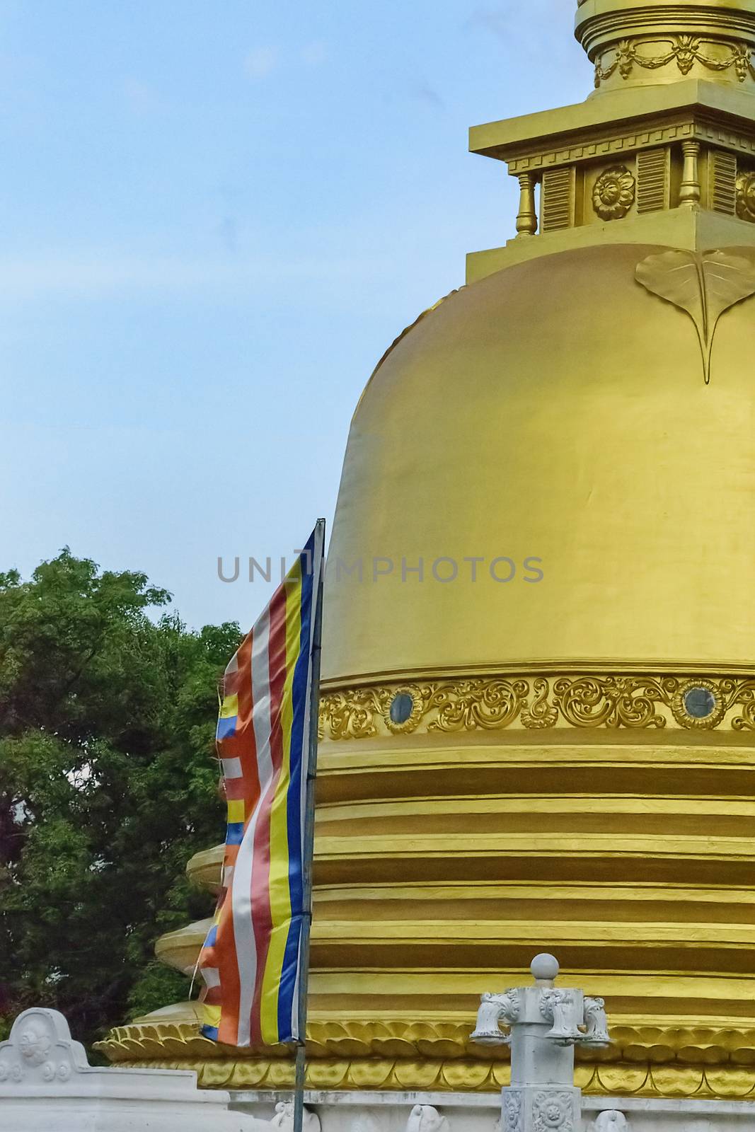 Dambulla, Sri Lanka, Aug 2015: Buddhist flag flies in front of one of the Golden Stupa an Dambulla Temple