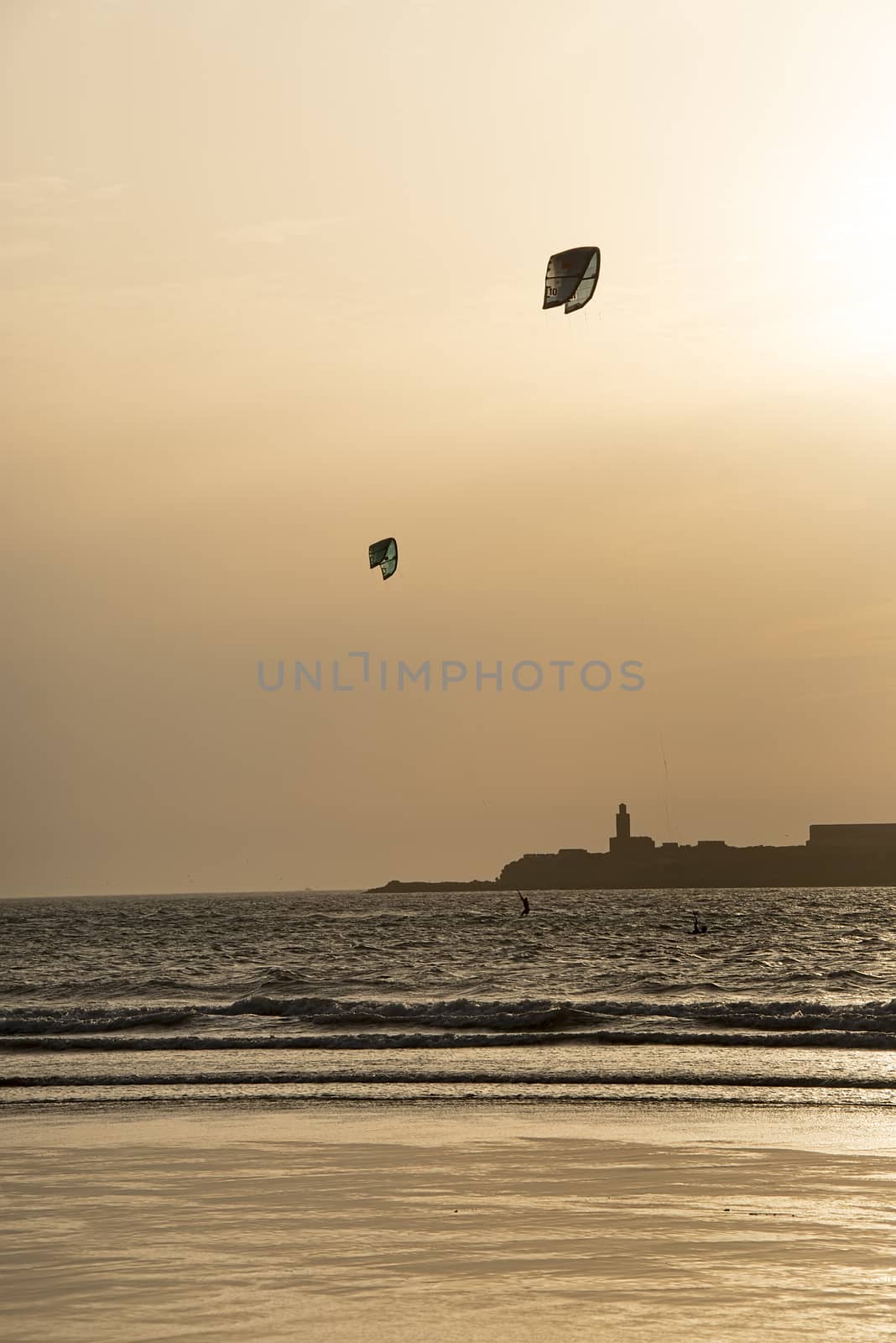 Essaouria, Morocco - September 2017: Early evening kite surfing as the sun starts to set over the ocean
