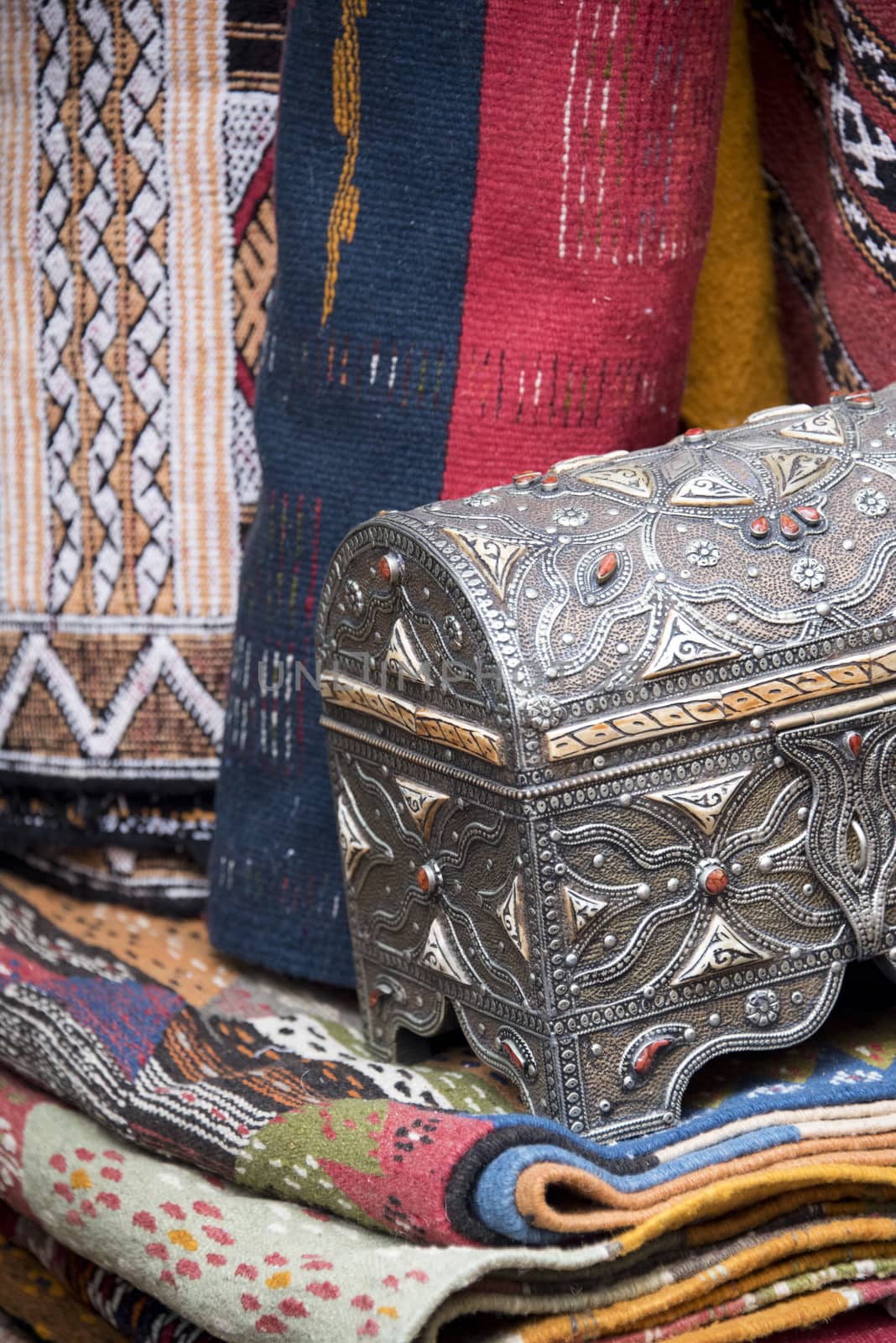 Essaouria, Morocco - September 2017: Ornate silver trinket box with colorful textiles on sale in a Moroccan Market
