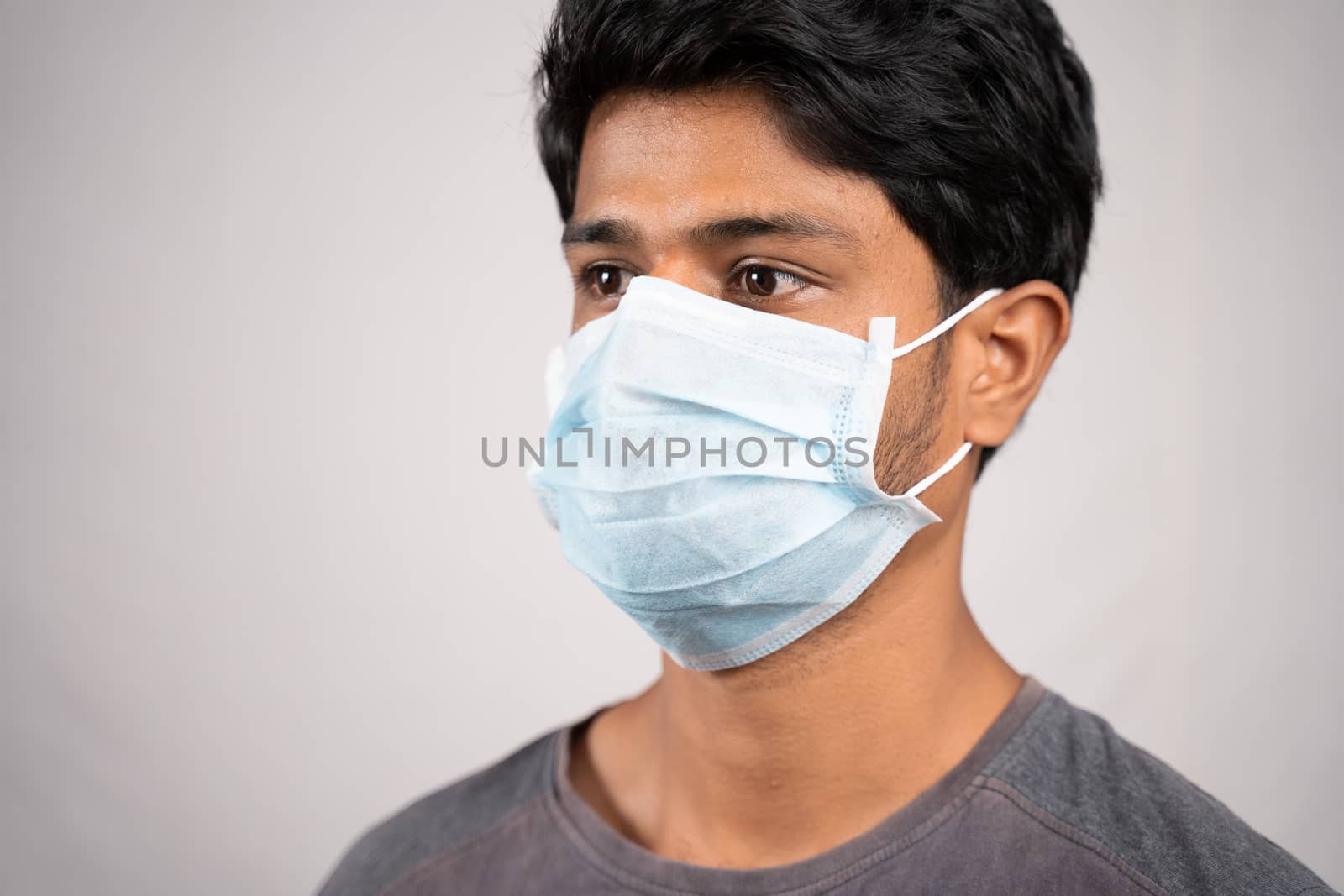 Young man properly covered nose and mouth with face mask - Awareness and safety concept to ware mask properly, to protect from coronavirus or covid-19 crisis on isolated background