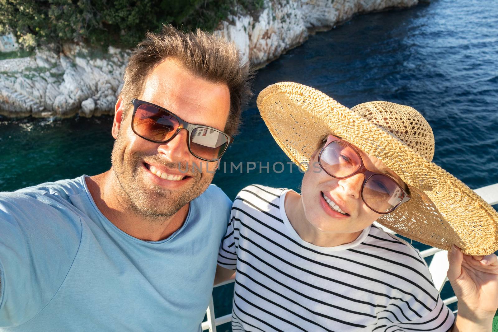Beautiful, romantic caucasian couple taking selfie self portrait photo on summer vacations traveling by cruse ship ferry boat. Relaxed cheerful lifestyle couple selfie.