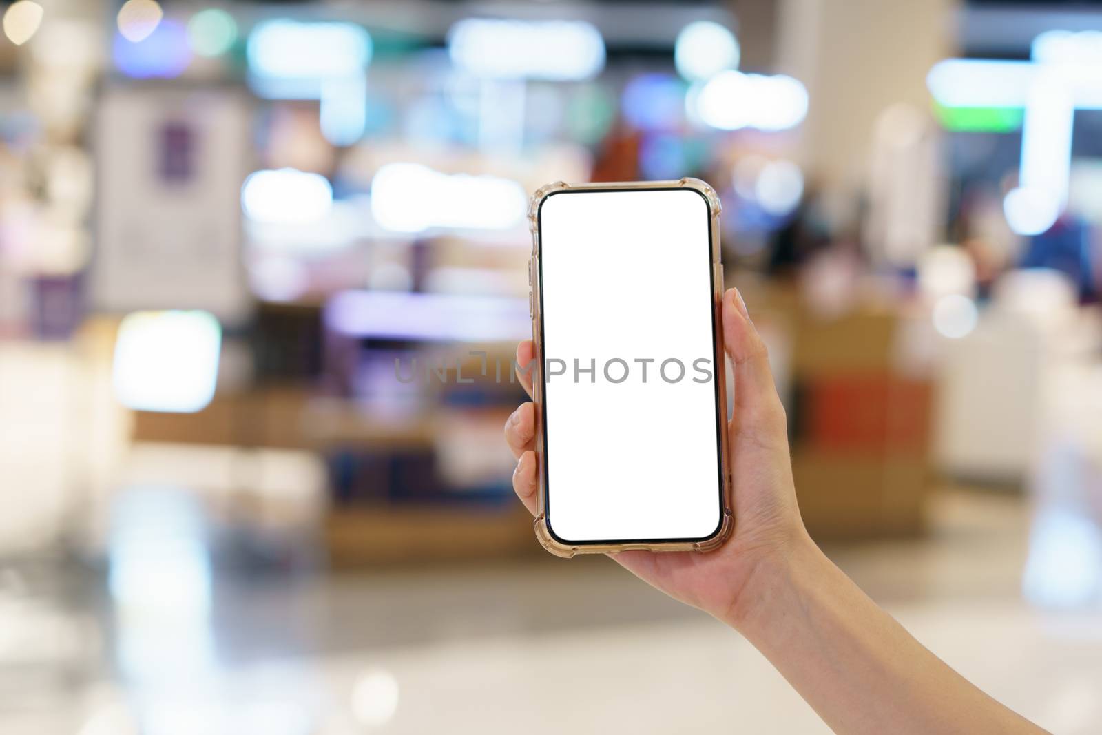 Mockup, hands holding blank white screen mobile phone in blurred department store, digital payment concept