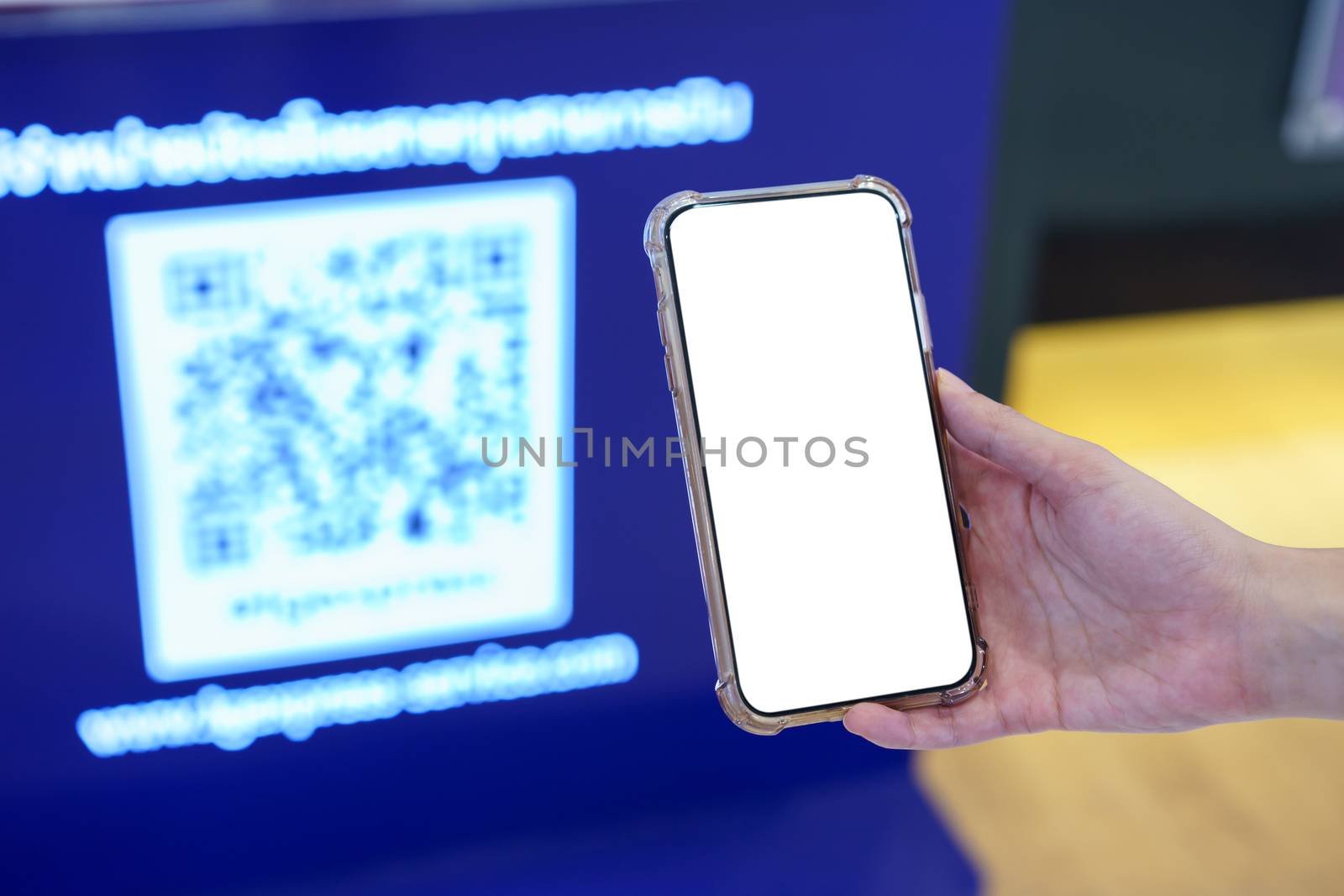 Mockup, hands holding blank white screen mobile phone in blurred QR code , digital payment concept
