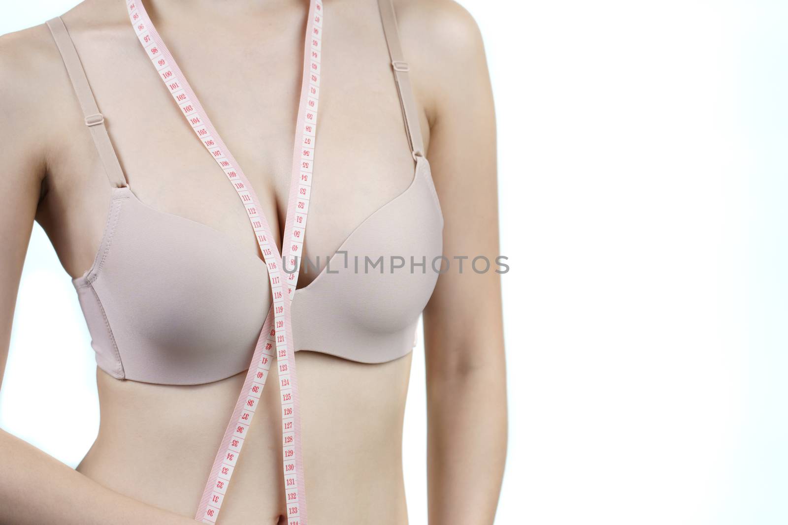 Woman measuring her chest for breast implant surgery.