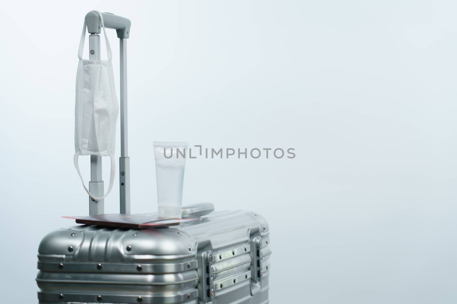Luggage passport boarding pass sanitizer bottle and face mask, new normal travel concept.