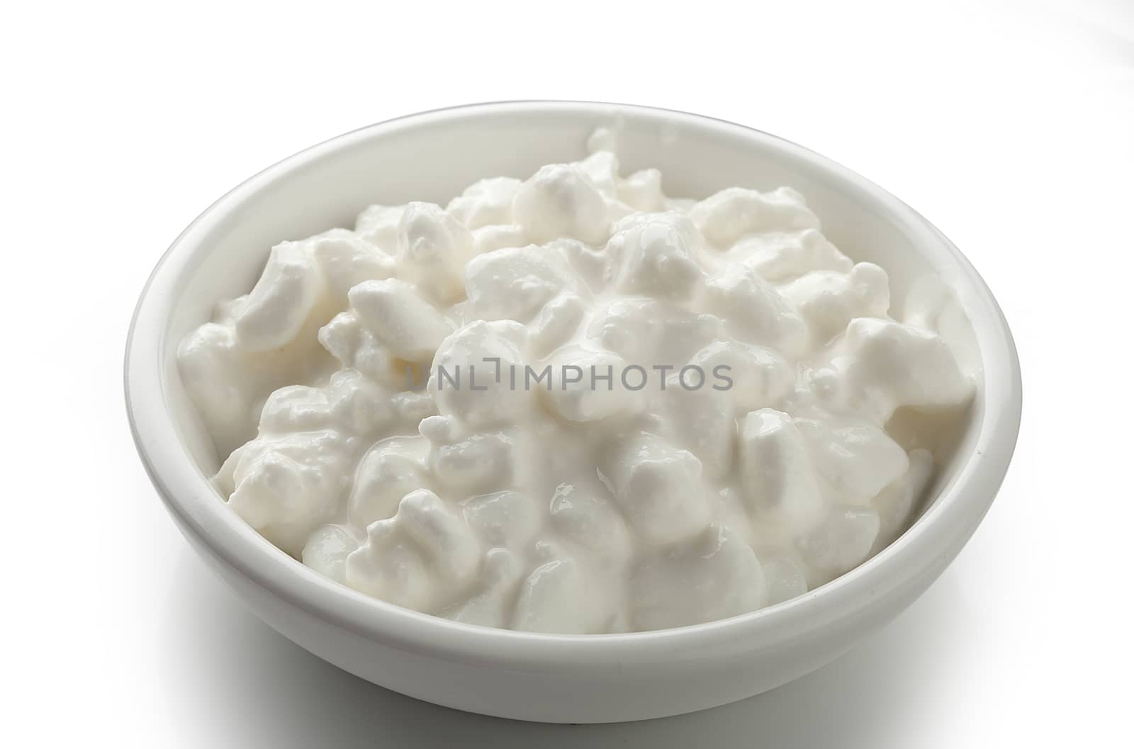 Grained cottage cheese in the white bowl