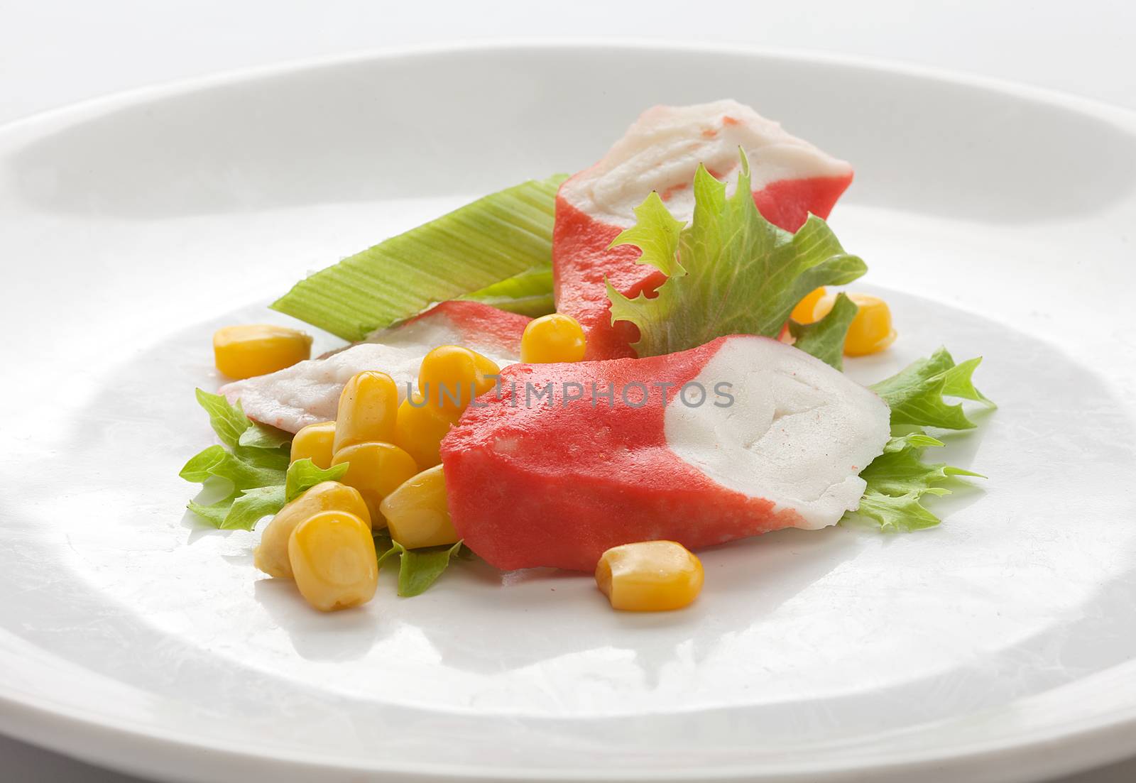Crab meat with fresh green lettuce and corn on the plate