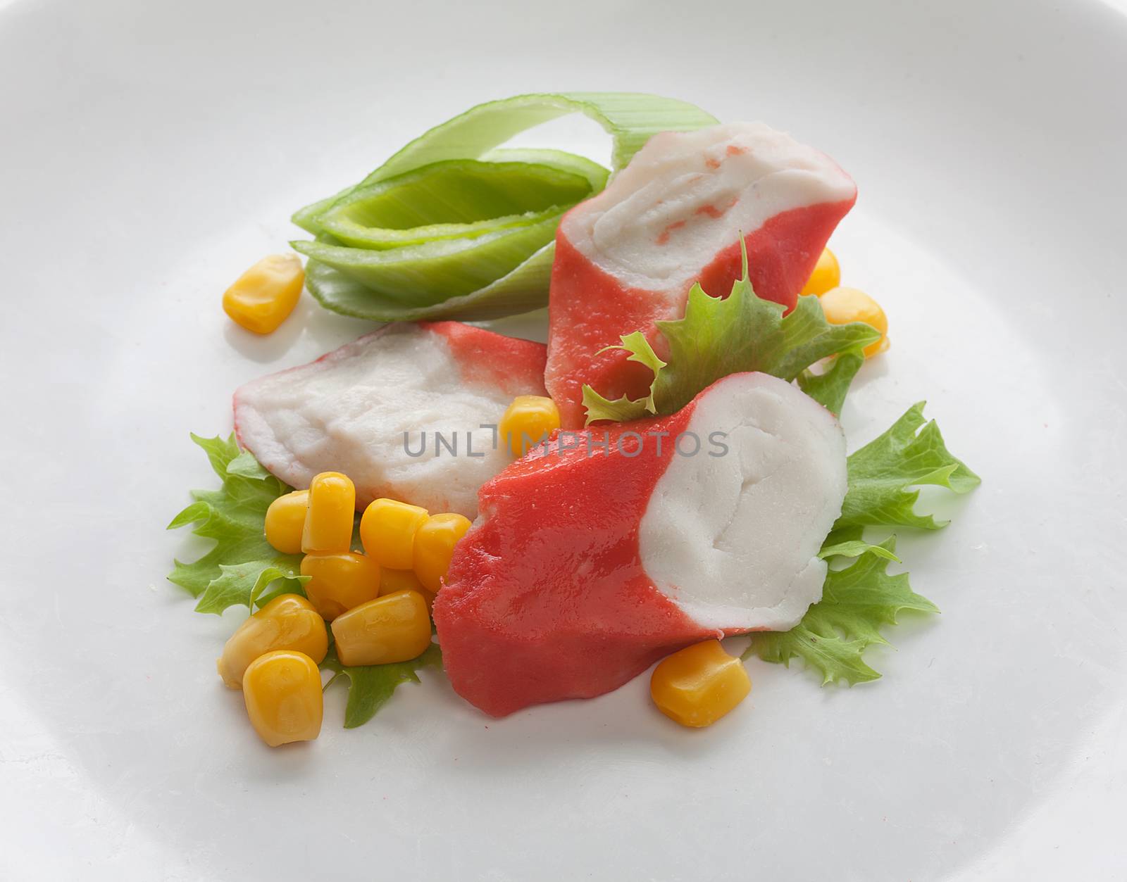 Crab meat with fresh green lettuce and corn on the plate