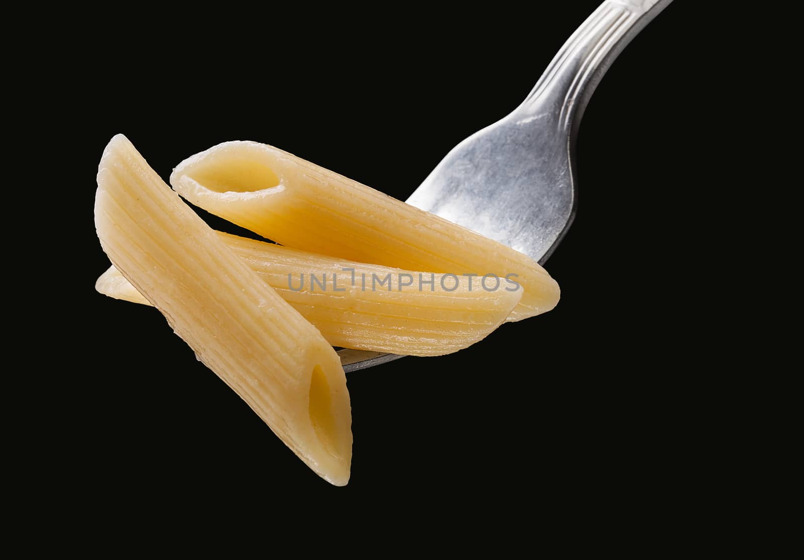 Pasta on the fork on the black background