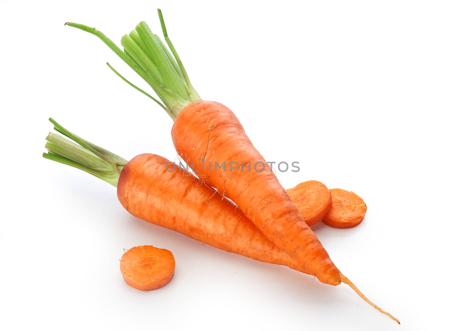 Isolated two fresh whole raw carrots with slices of carrot on the white background