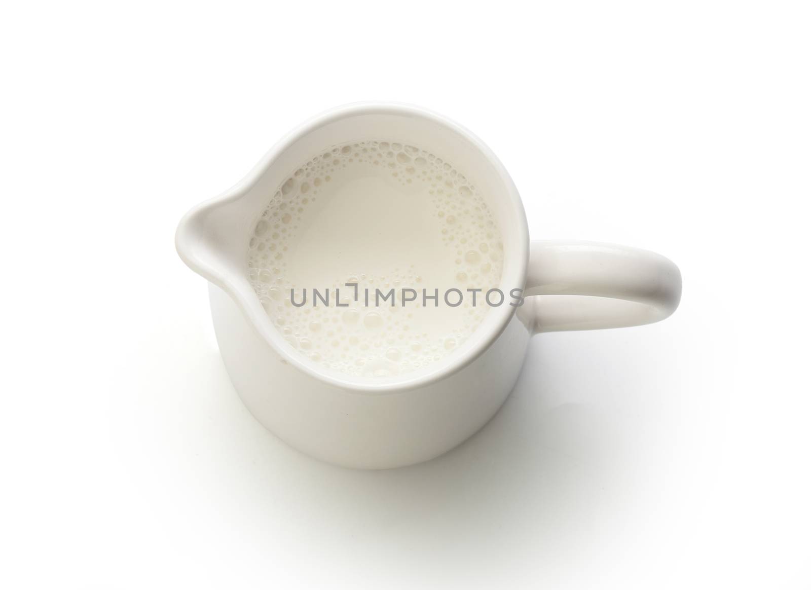 Top view of milk jug with milk on the white