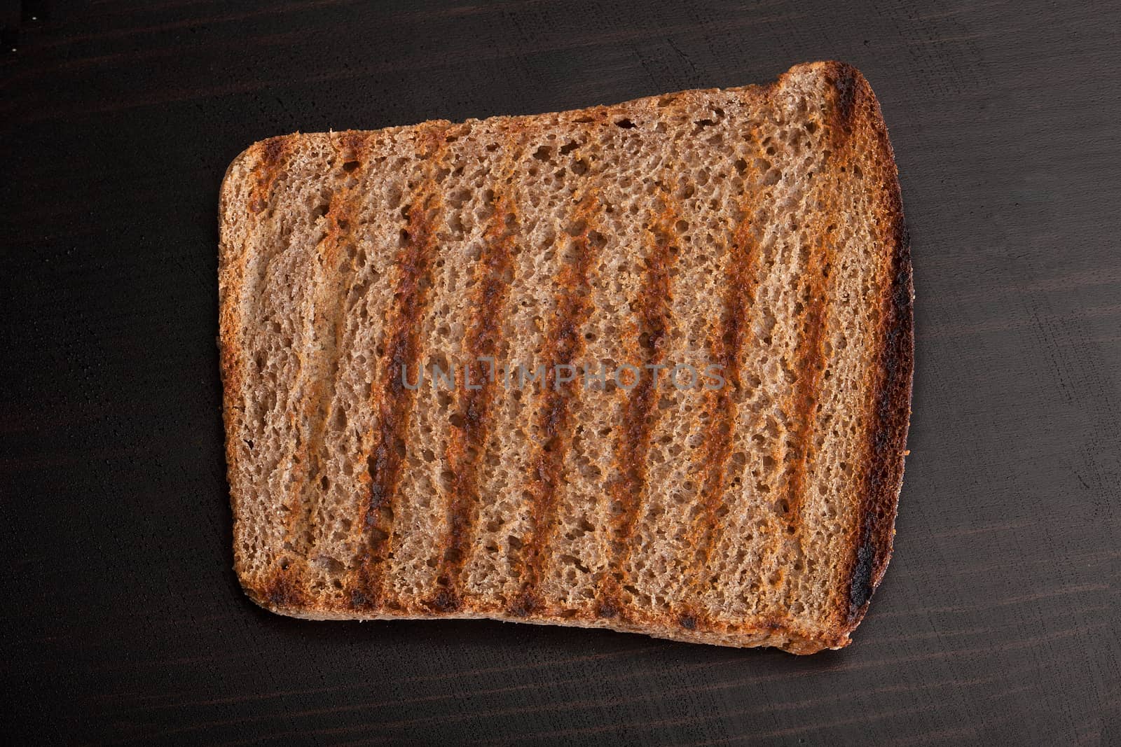 Toasted rye bread on the wooden table by Angorius