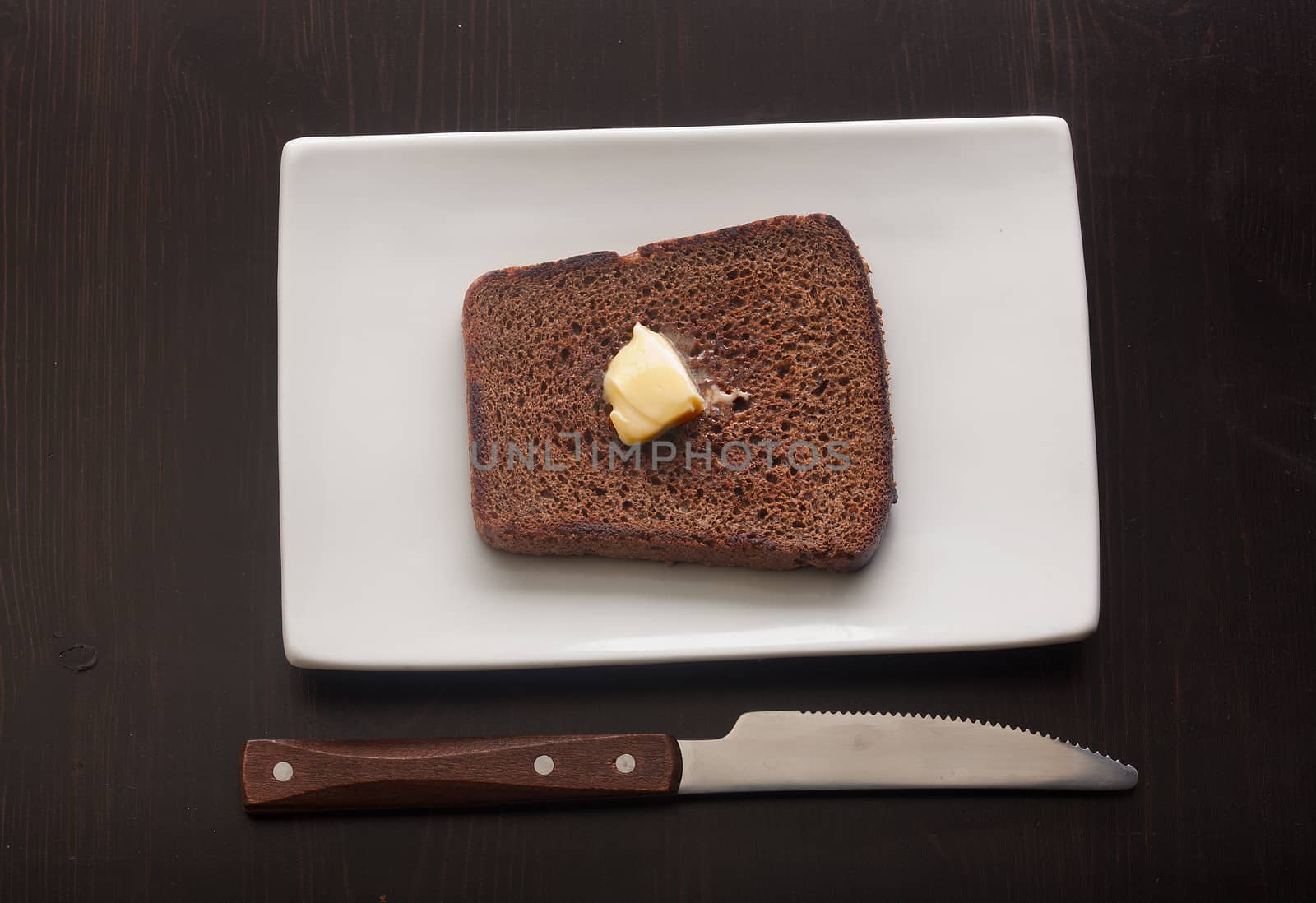 Top view of toasted custard rye bread with butter on the white plate
