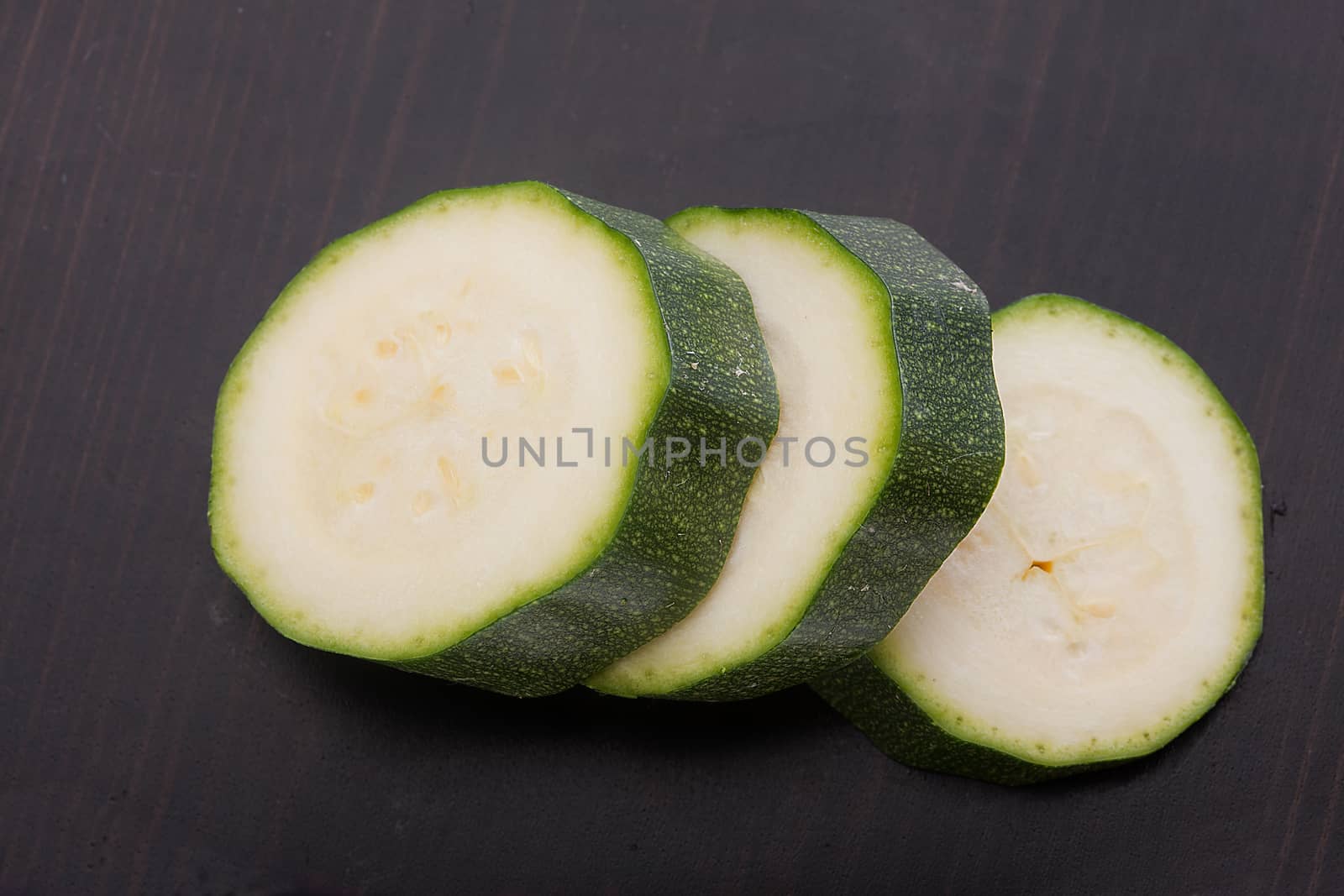 Top view of green zucchini slices on the white background