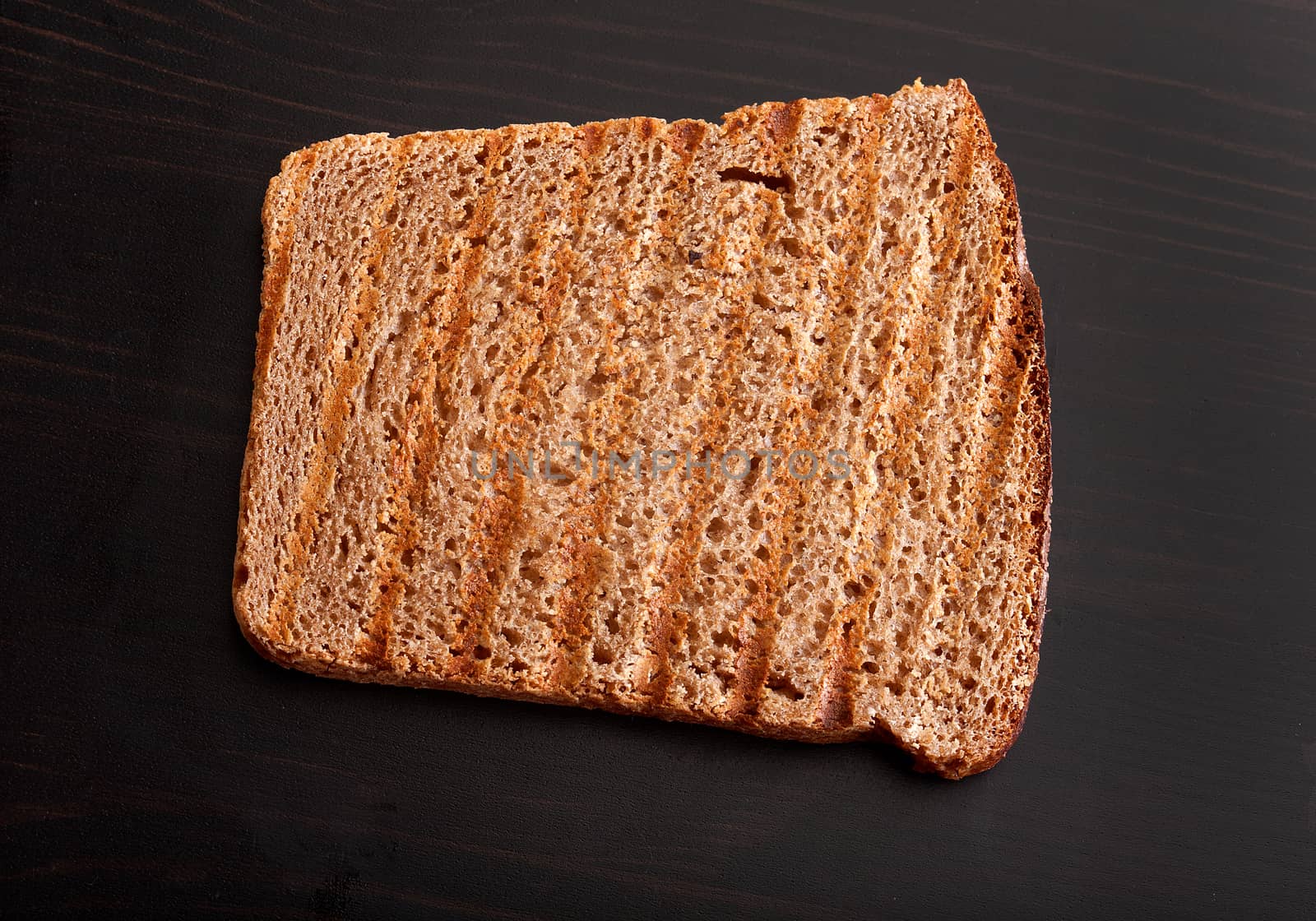 Top view of roasted rye bread on the black wooden table