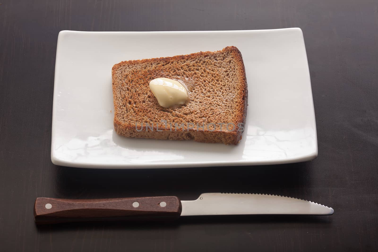 Toasted rye bread on the white plate by Angorius