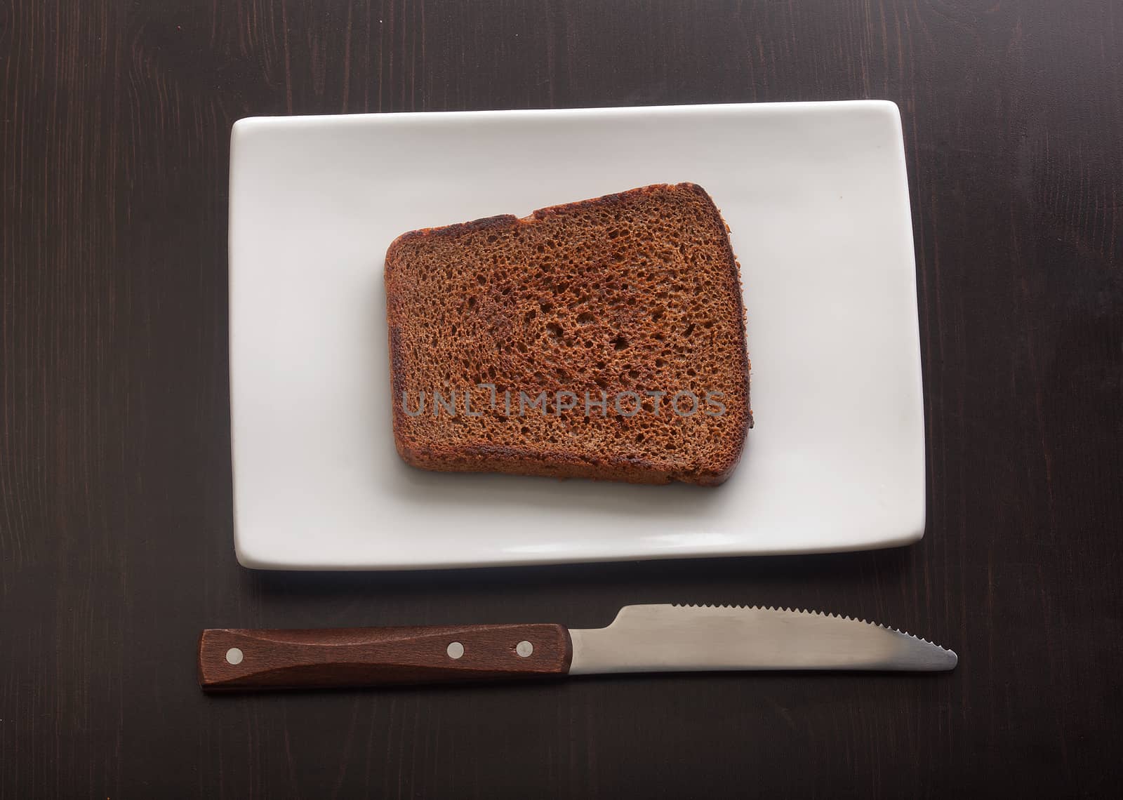 Toasted rye bread on the white plate by Angorius