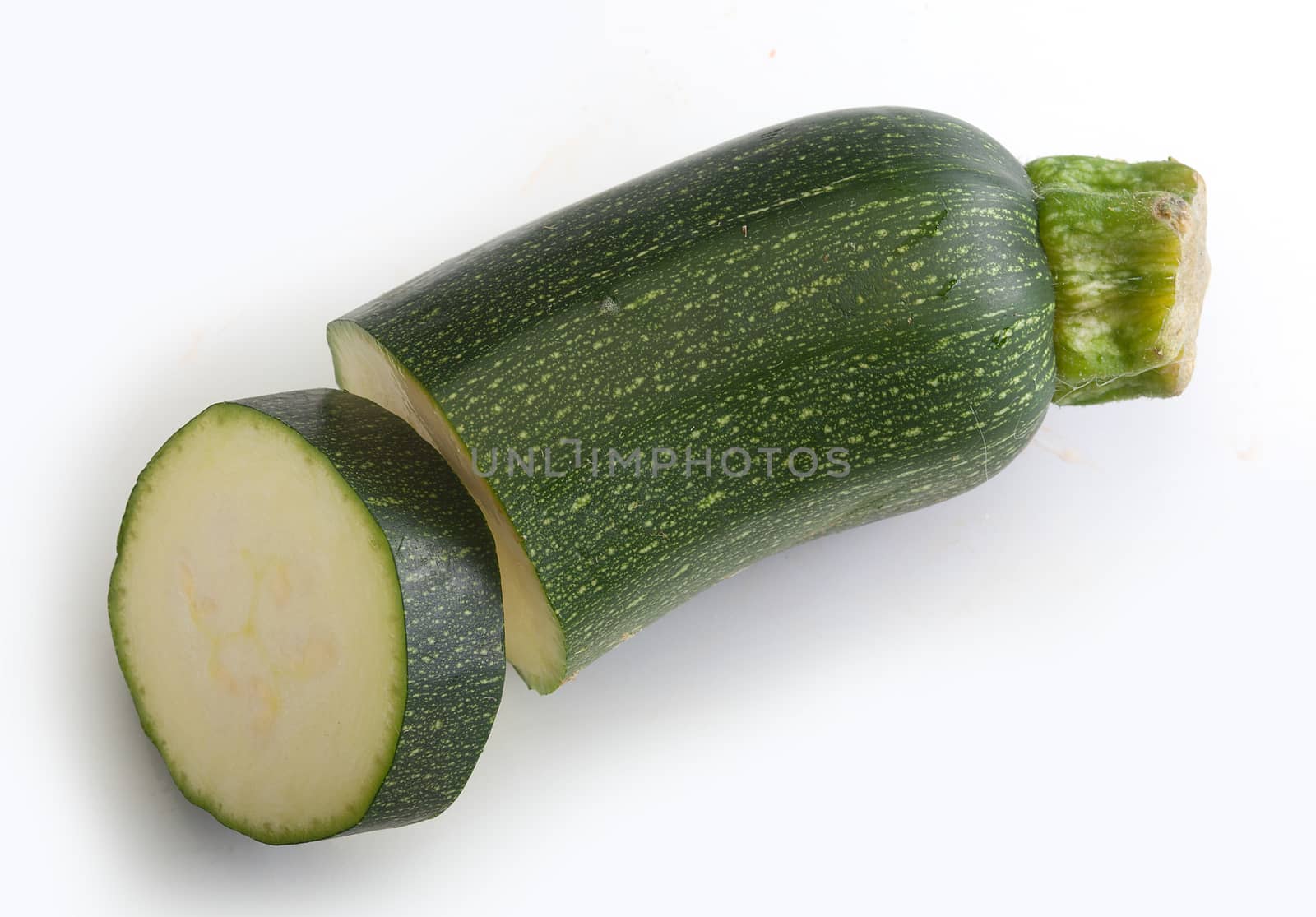 Isolated pieces of green zucchini on the white background