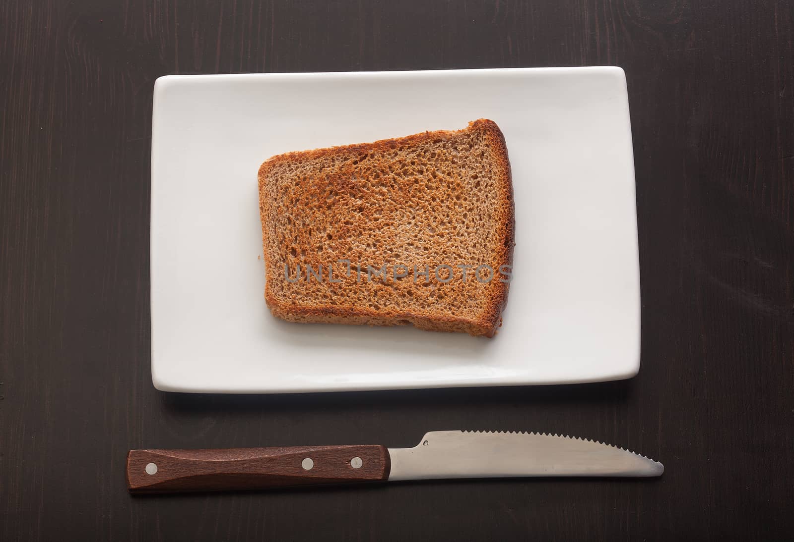 Toasted rye bread on the white plate by Angorius