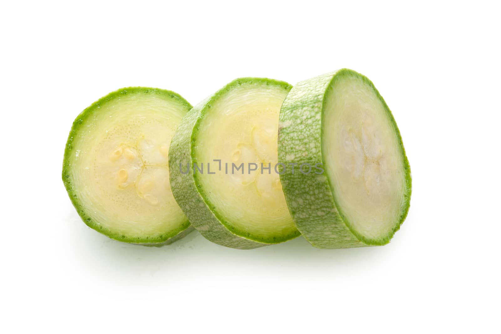 Top view of three green pieces of vegetable marrow on the white background