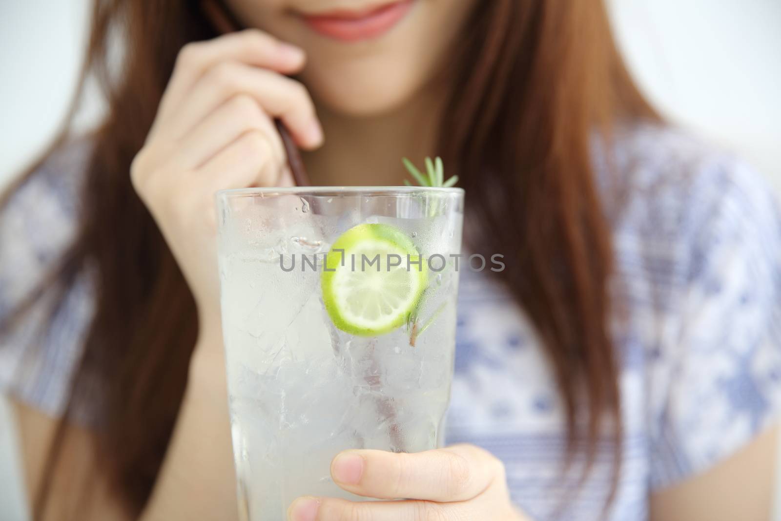 woman drinking lime juice in white coffeeshop