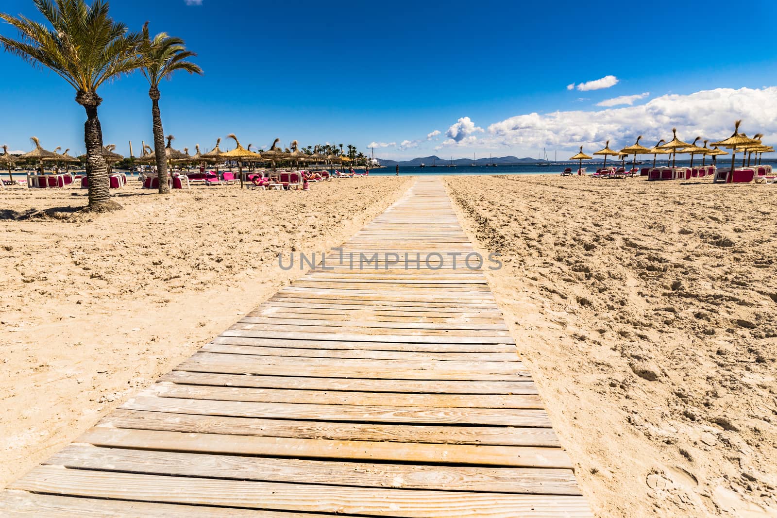 Wooden footpath on the sand beach on Mallorca island, beautiful seaside coast of Alcudia bay, Spain Balearic Islands