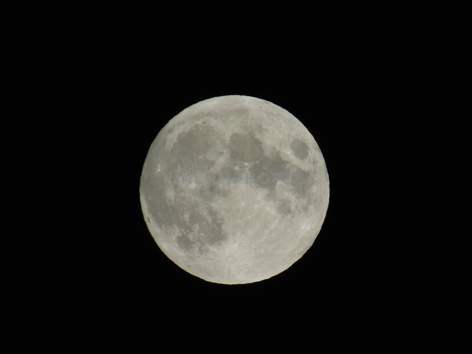 Genova, Italy - 07/05/2020: An amazing photography of the full moon over the city of Genova by night with a great clear and blue sky in the background and some stars.