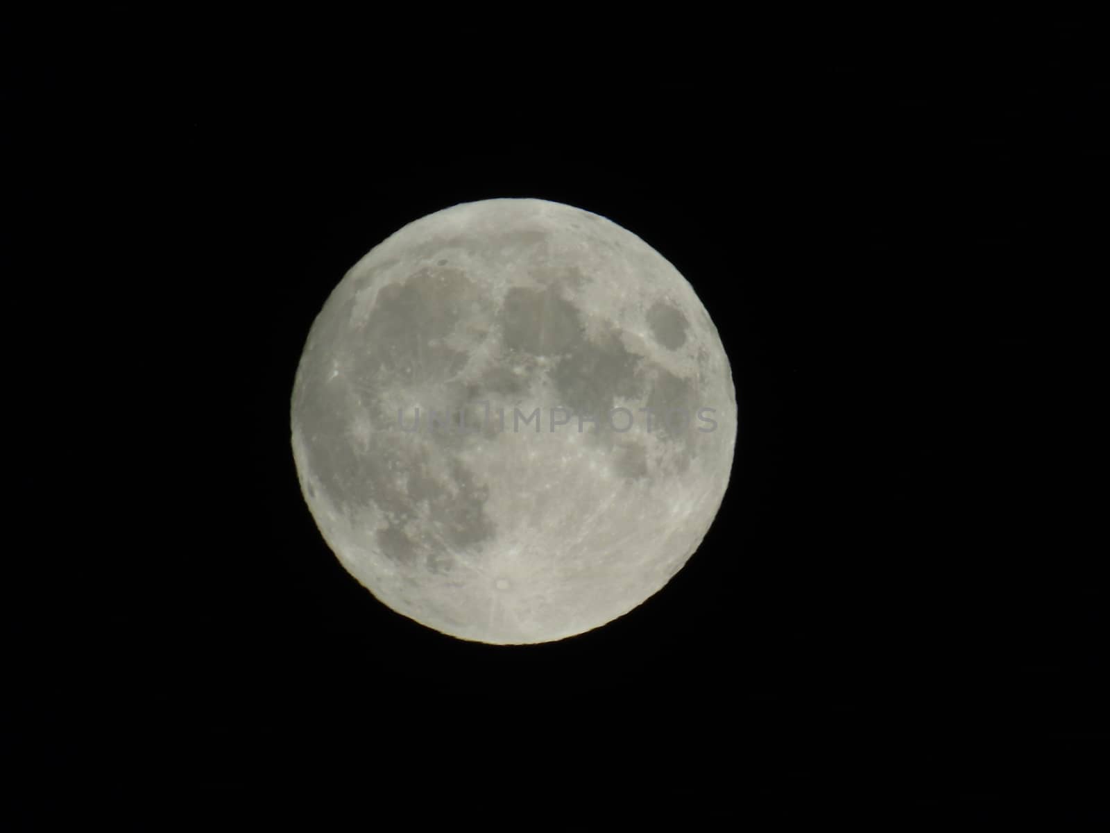 Genova, Italy - 07/05/2020: An amazing photography of the full moon over the city of Genova by night with a great clear and blue sky in the background and some stars.