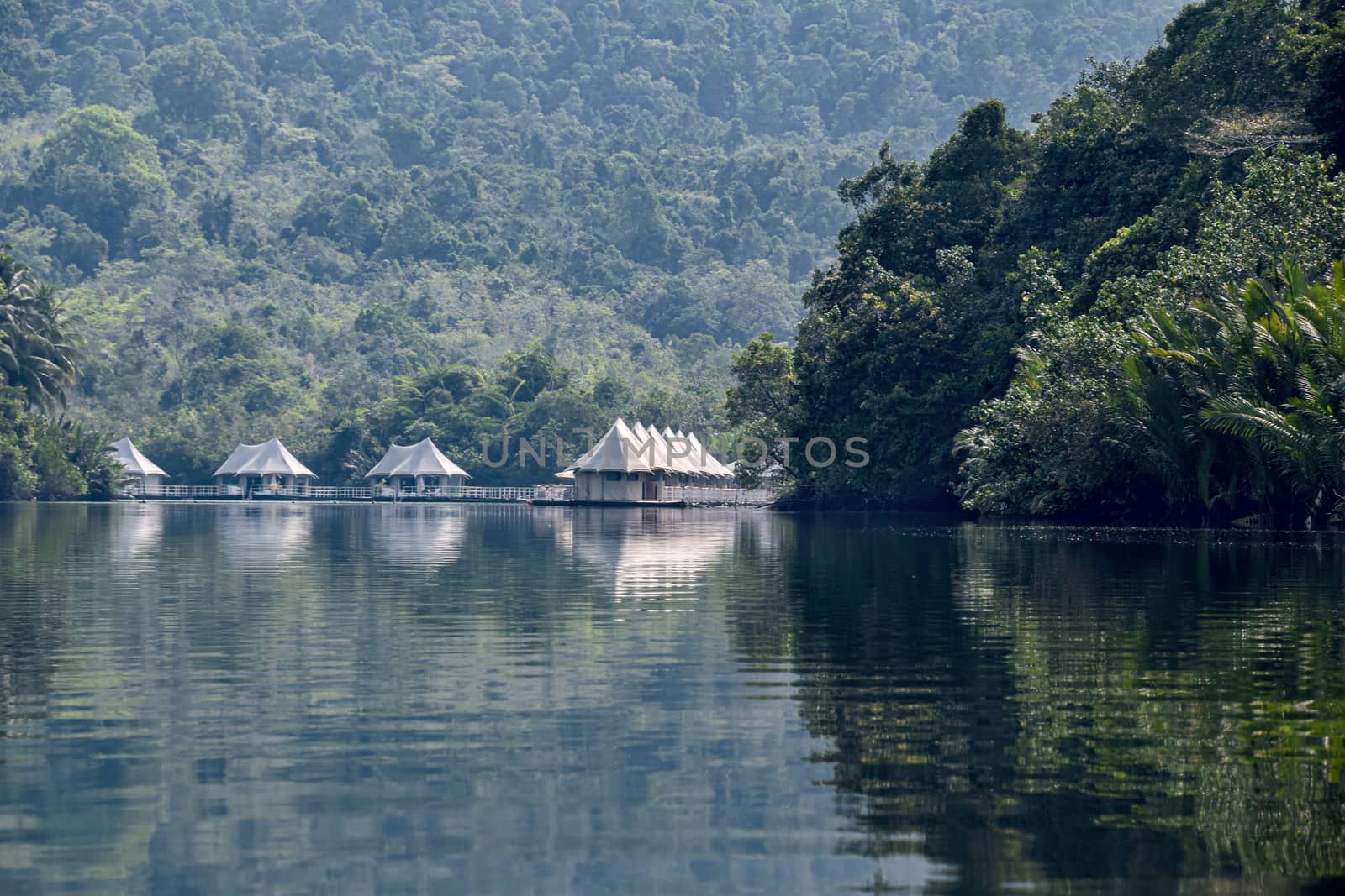 Cambodia, Ko-Hong - March 2016: 4 rivers tented jungle ecotourism hotel coming into view around a bend in the Kong River - daylight