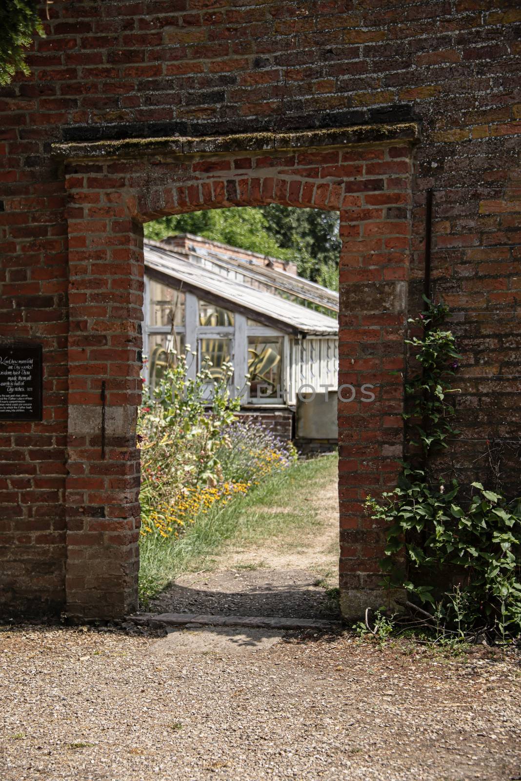 UK, Launde Abbey, Leicestershire - July 2018: Brick opening frames the entry to a walled