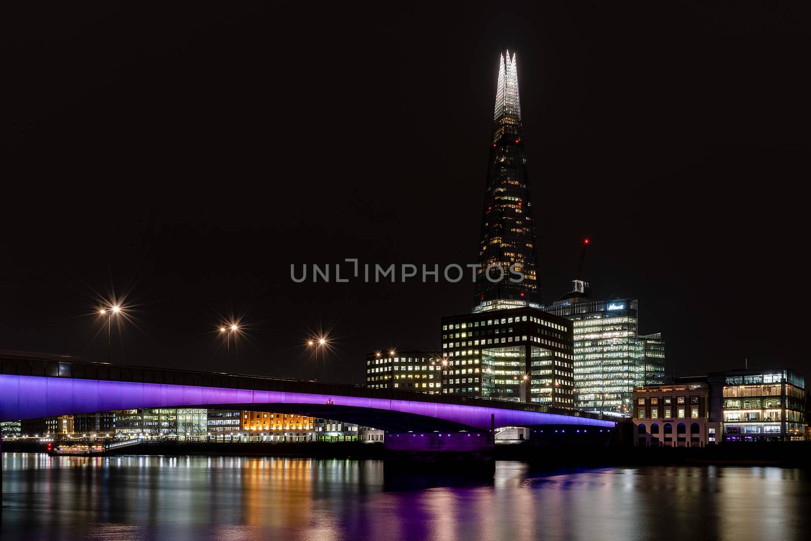 London, UK - Jan 2020: The Shard and London Bridge illuminated and reflecting in the Thames