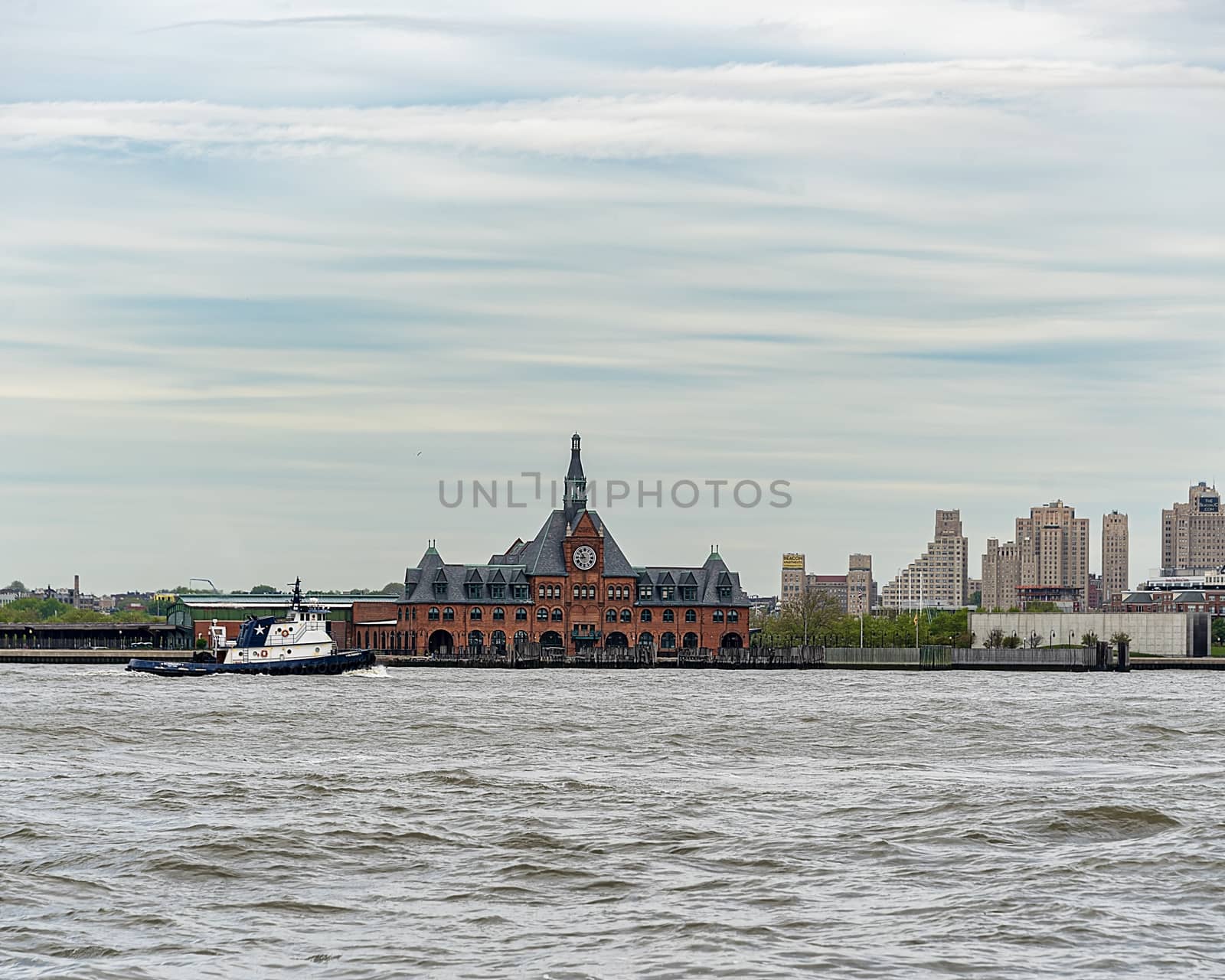 USA, New York - May 2019: Tug boat passing Central Railroad of New Jersey Terminal