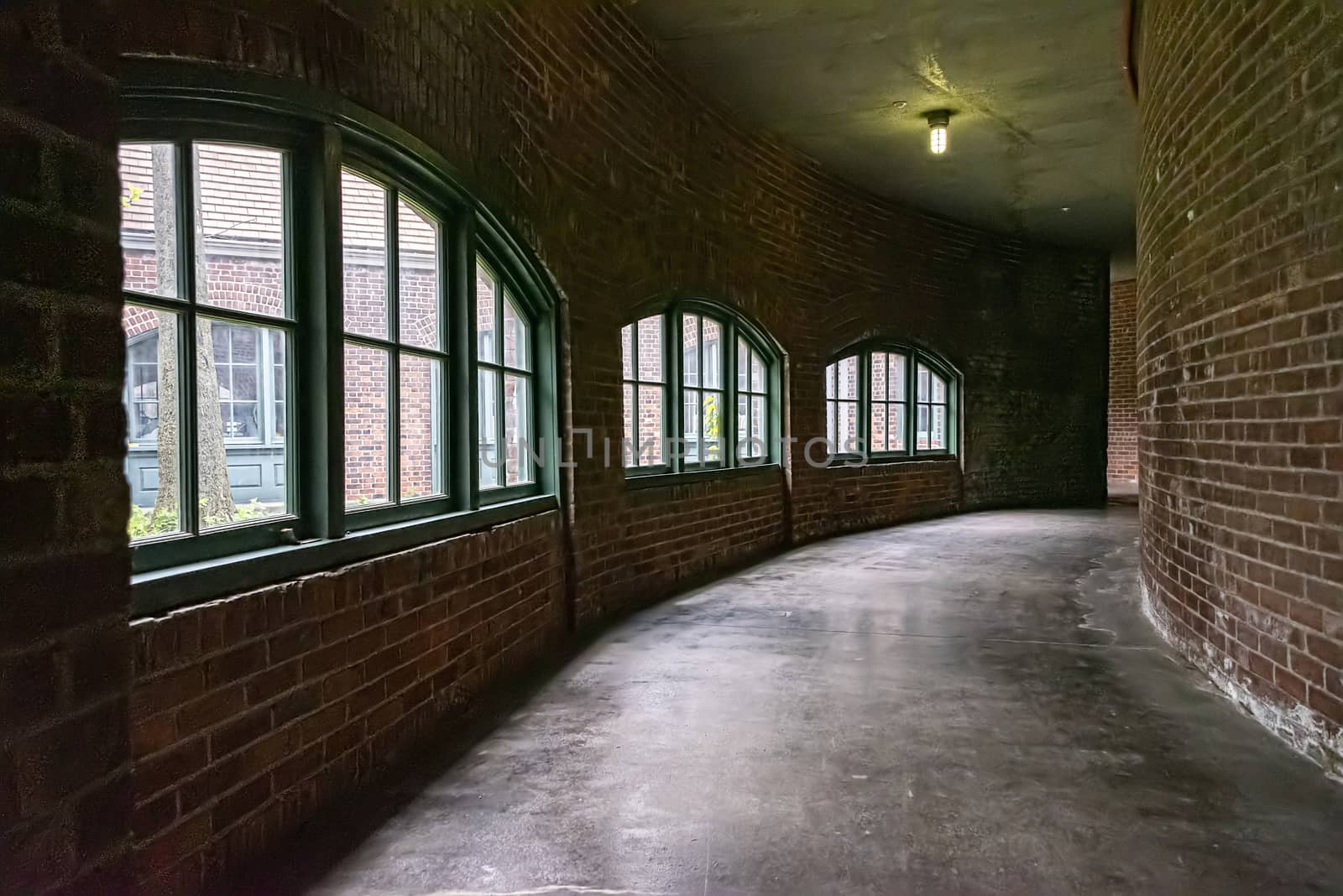 USA, New York, Ellis Island - May 2019: Long curved corridor walled with arched window panels