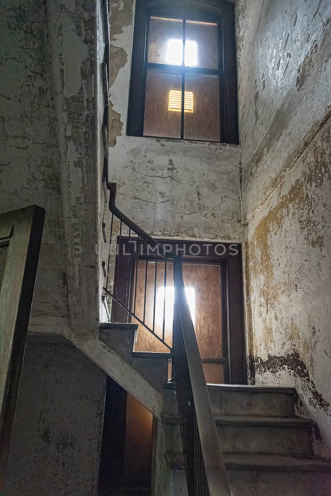 USA, New York, Ellis Island - May 2019: View up wooden stair case in boarded up, dilapidated house