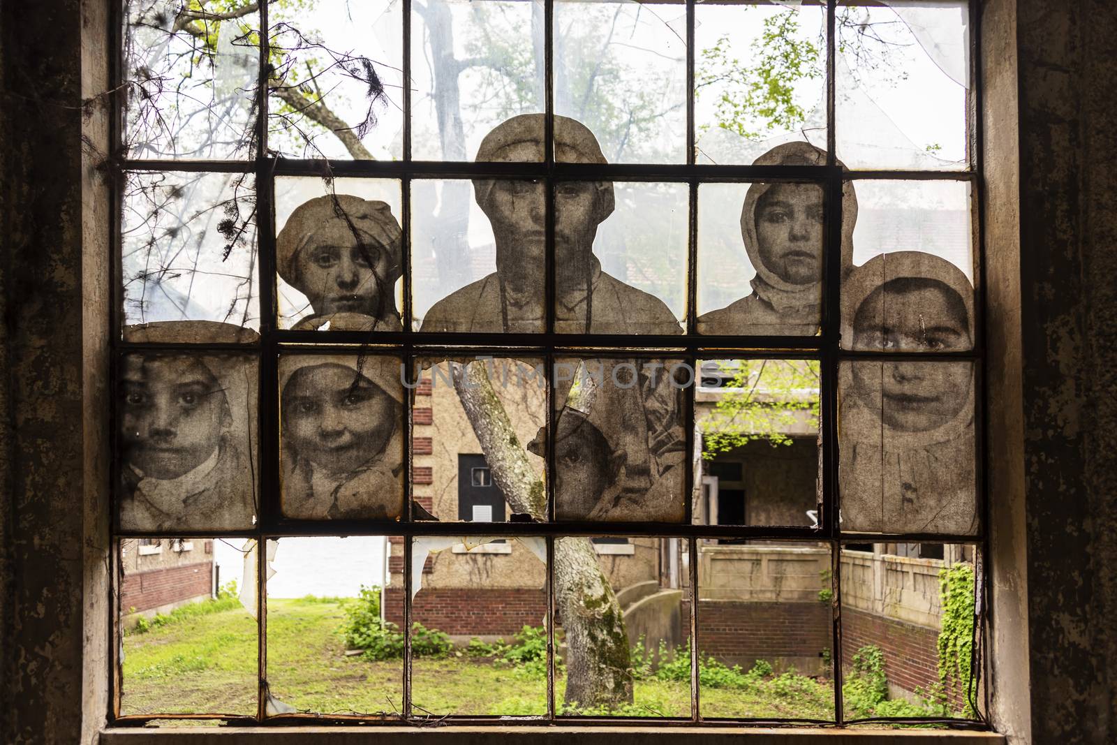 USA, New York, Ellis Island - May 2019:Art installation by JR , faces of Immigrants in a  corridor of Ellis Island Hospital 