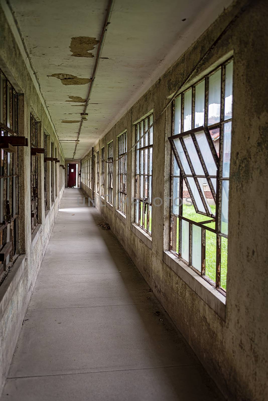 USA, New York, Ellis Island - May 2019: decayed corridor leading to a red exit door