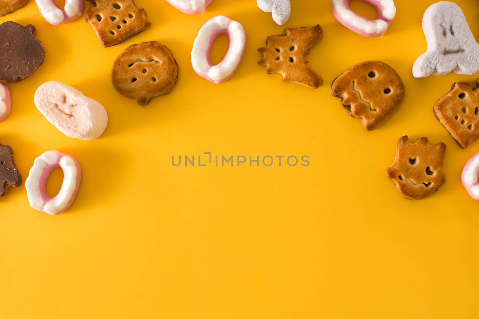 Assortment of Halloween cookies on yellow background
