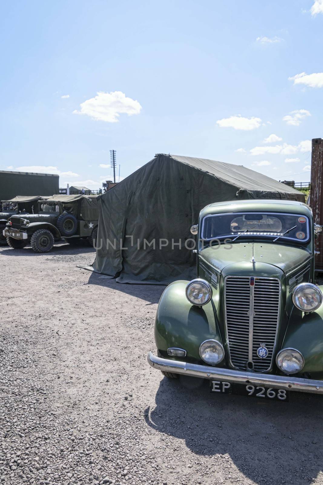 Vintage military vehicles parked outside of army tents	 by mrs_vision