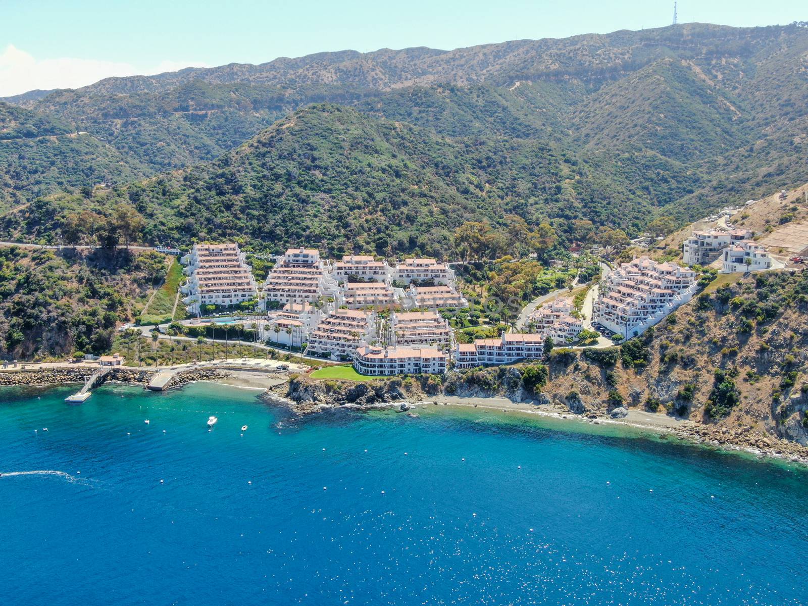 Aerial view of Hamilton Cove with apartment condo building on the cliff, Santa Catalina Island, famous tourist attraction in Southern California, USA