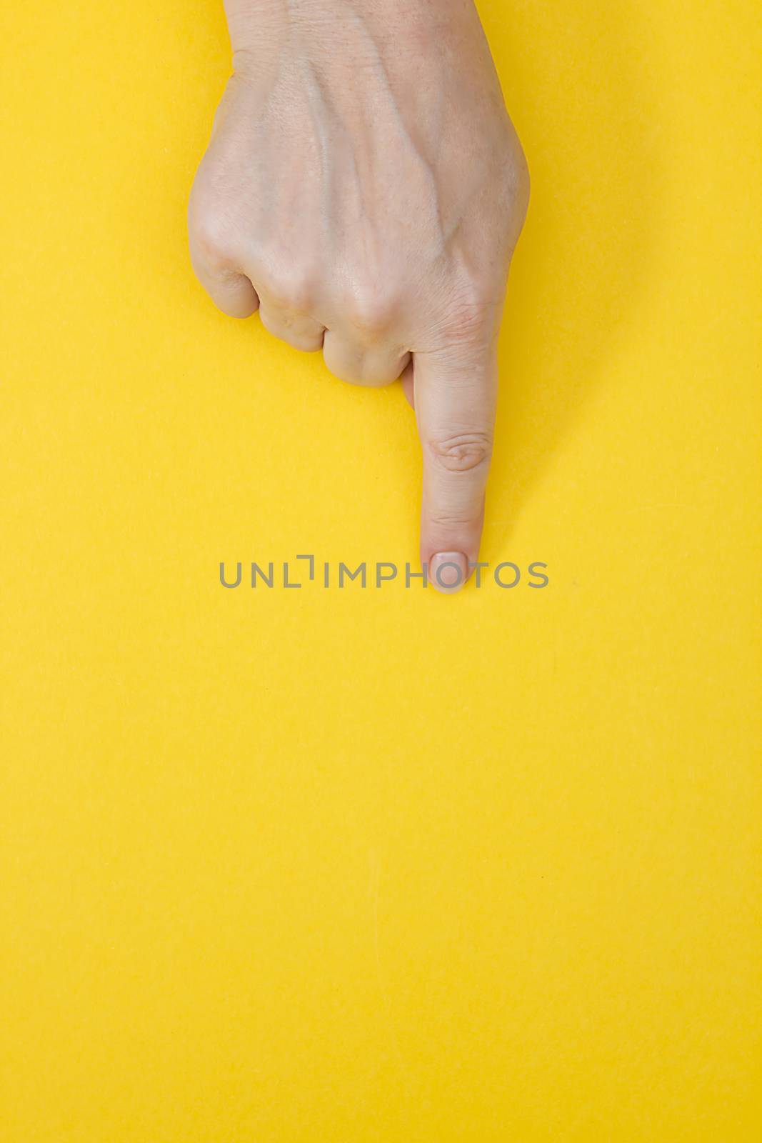 Woman's hand touching virtual screen on yellow background