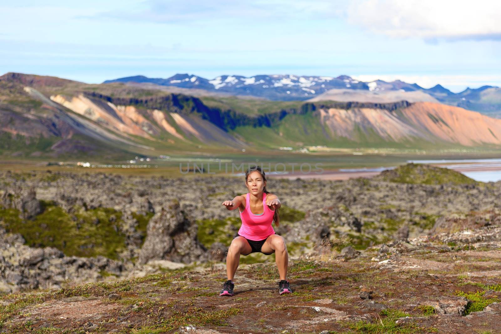 Fitness girl exercising outdoors doing jump squat in amazing nature landscape. Fit female woman athlete cross-training outside. Image from Iceland.