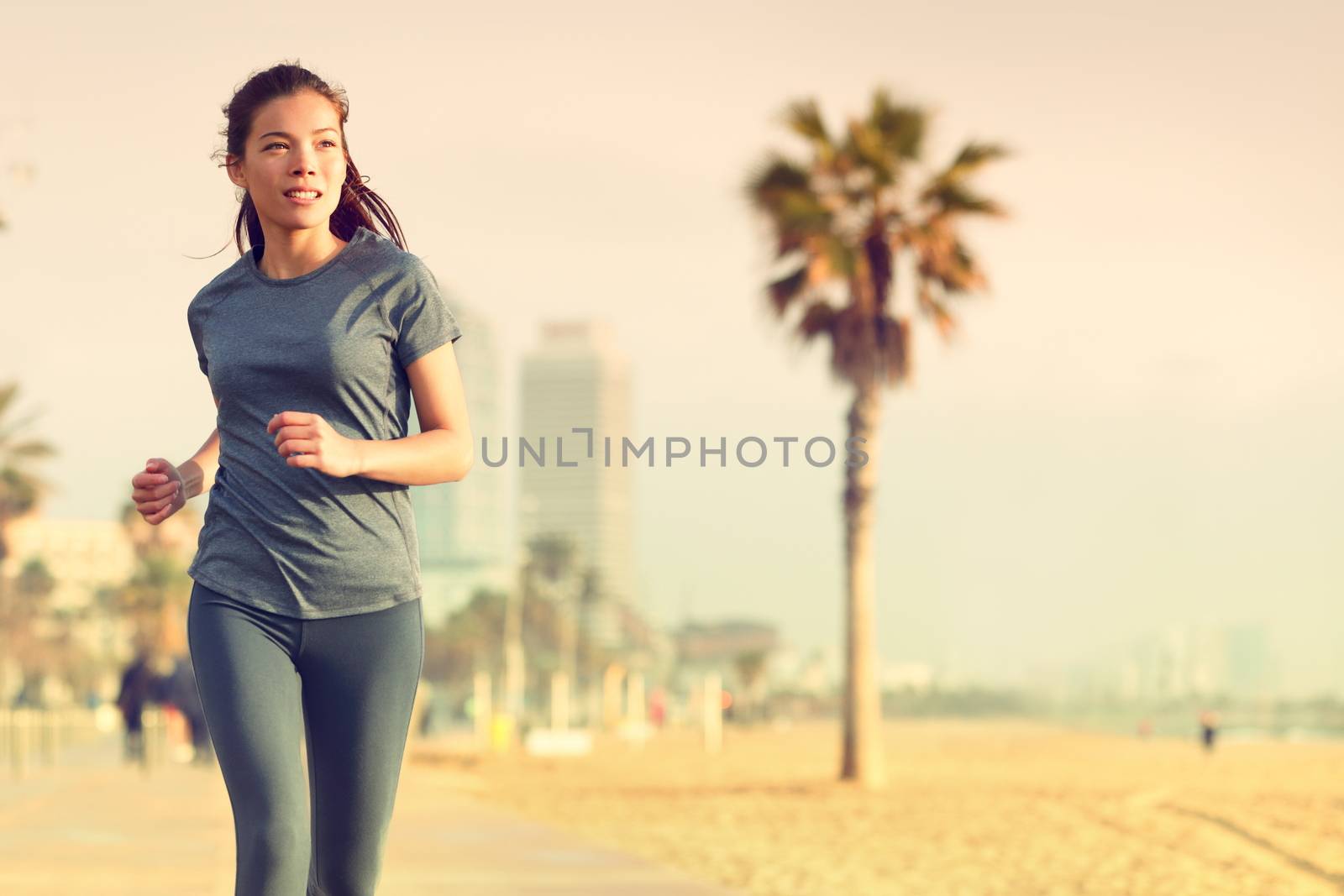 Running woman jogging on beach boardwalk. Healthy lifestyle girl runner training outside working out. Mixed race Asian Caucasian fitness woman exercising outdoors.