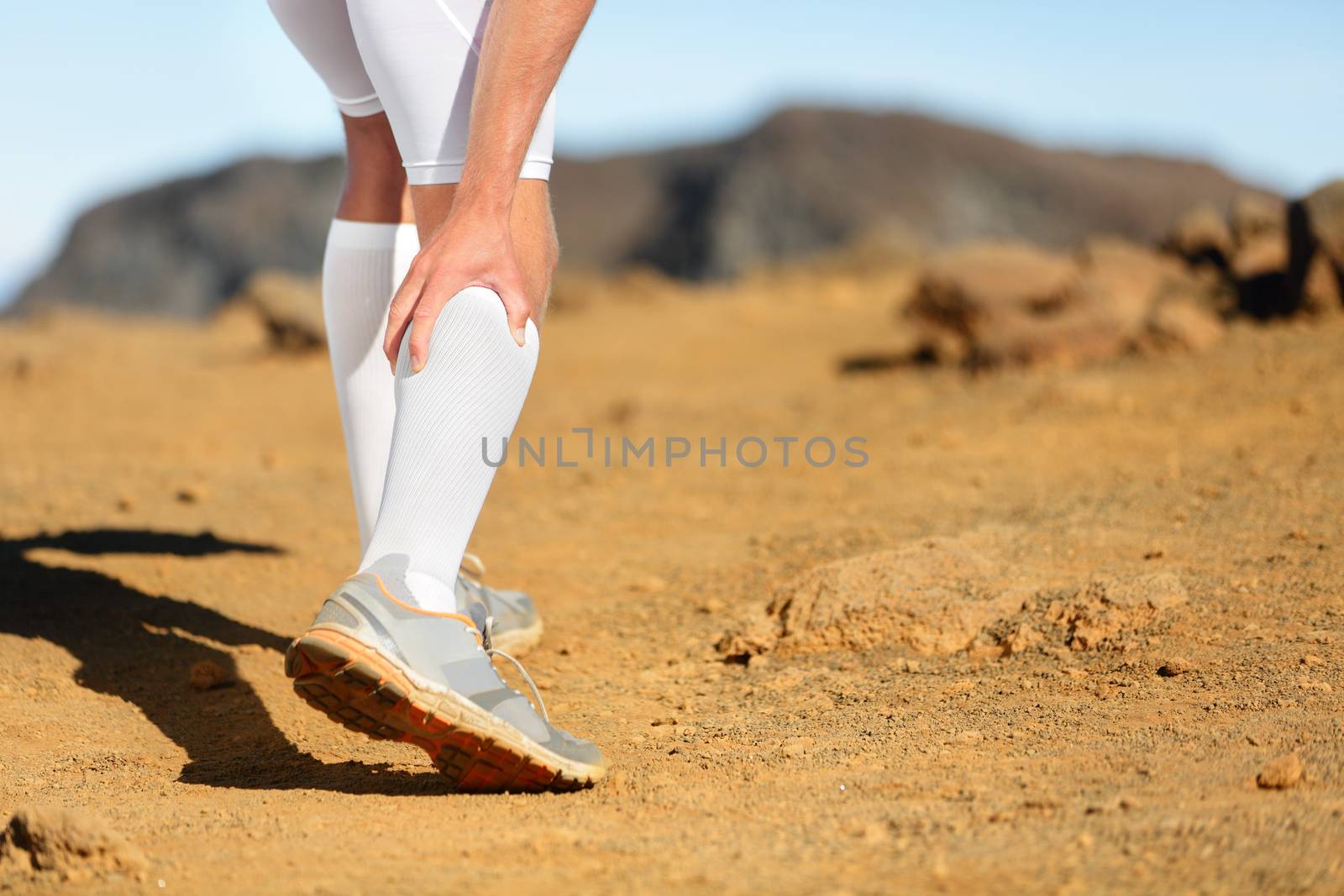 Running Cramps in leg calves or sprain calf on runner. Sports injury concept with running fitness man athlete outside.