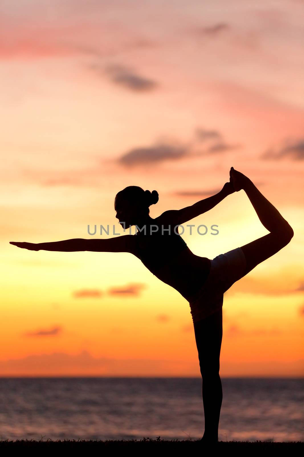 Yoga woman in serene sunset at beach doing pose by Maridav