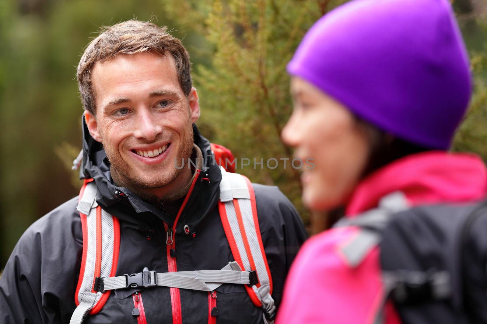 Male hiker portrait in forest talking with woman by Maridav